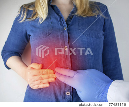 A woman grabs his right side under the ribs. Pain in the liver. Pain syndrome in liver disease. Hepatologist examination A woman grabs his right side under the ribs. Pain in the liver. Pain syndrome in liver disease. Hepatologist examination 77485156