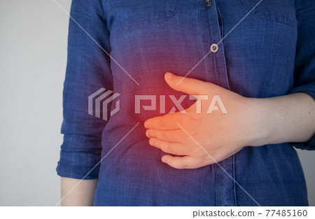 A woman grabs his right side under the ribs. Pain in the liver. Pain syndrome in liver disease. Hepatologist examination A woman grabs his right side under the ribs. Pain in the liver. Pain syndrome in liver disease. Hepatologist examination 77485160