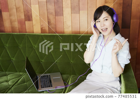 A woman listening to music 77485531