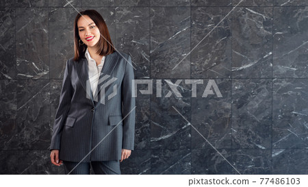 Beautiful brunette in a business gray suit Beautiful brunette in a business gray suit 77486103
