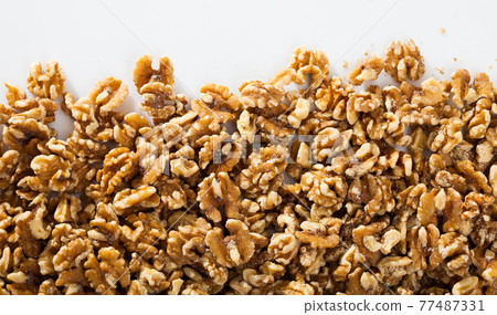 Shelled walnuts on white surface 77487331