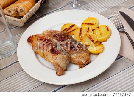 Image of grilled pork with potatoes served at plate 77487387