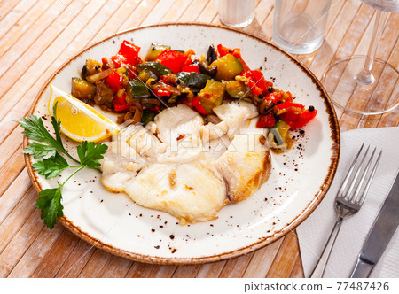 Baked steak of shark with stewed vegetables and lemon 77487426