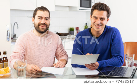 Men discuss and sign apartment sale contract agreement at home Men discuss and sign apartment sale contract agreement at home 77488517