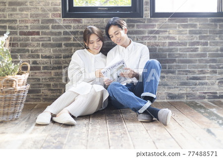 一對夫婦放鬆地看雜誌 77488571