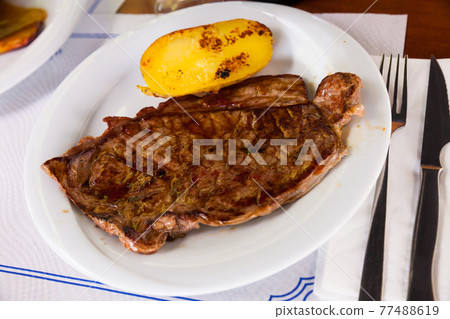 Beef steak with potatoes on a white plate 77488619