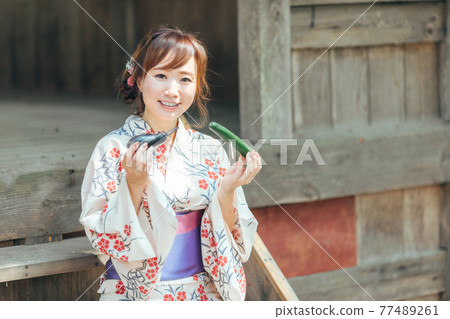 一個身著浴衣並奉上盂蘭盆祭的女人 77489261