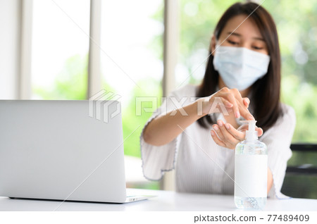 using alchohol gel washing hand during work at office 77489409