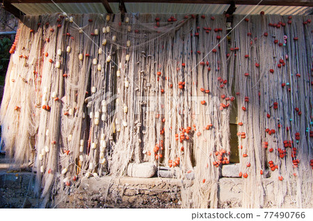 fishing nets with floats and weights hung out to dry fishing nets with floats and weights hung out to dry 77490766