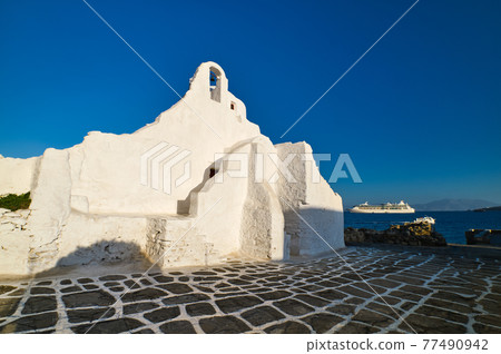 Famous tourist landmark, Mykonos, Greece. White Greek Orthodox church of Panagia Paraportiani, town of Chora on island at sunrise. Iconic destination Famous tourist landmark, Mykonos, Greece. White Greek Orthodox church of Panagia Paraportiani, town of Chora on island at sunrise. Iconic destination 77490942