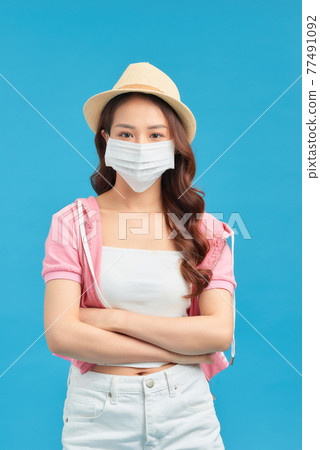 Portrait of gorgeous woman wearing face mask and hat while standing in studio Portrait of gorgeous woman wearing face mask and hat while standing in studio 77491092
