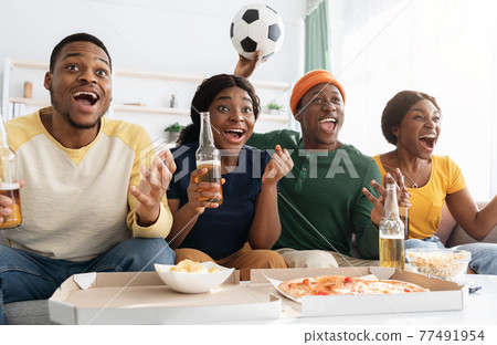 Emotional african american friends watching football match together 77491954