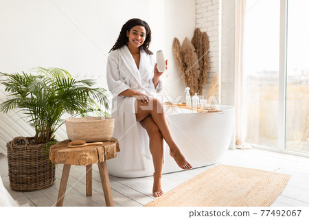 Happy Black Lady Showing Shampoo Advertising Cosmetic Product In Bathroom 77492067