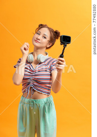 Happy Asian woman using action camera selfie herself 77492880