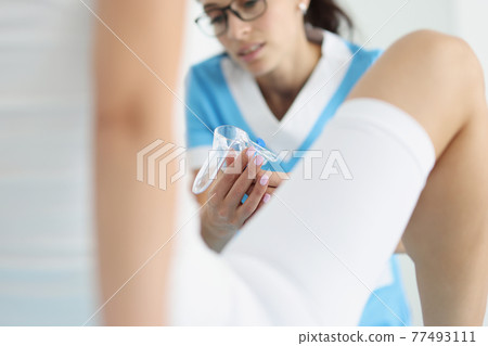 Doctor gynecologist examining woman using medical instrument mirror closeup 77493111