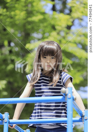 Elementary school girl climbing a jungle gym (6 years old) Elementary school girl climbing a jungle gym (6 years old) 77494841