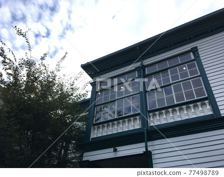 Old building with white clouds and green walls in the evening 77498789
