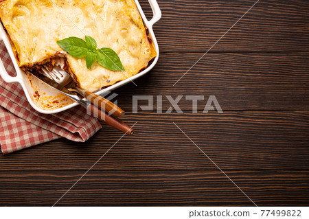 Traditional Italian lasagna in casserole pan on wooden table 77499822