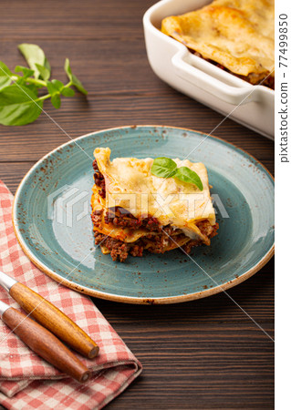 Traditional Italian lasagna on plate on wooden table 77499850