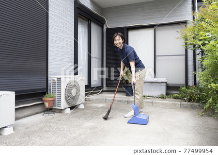 House cleaning woman sweeping the parking lot 77499954