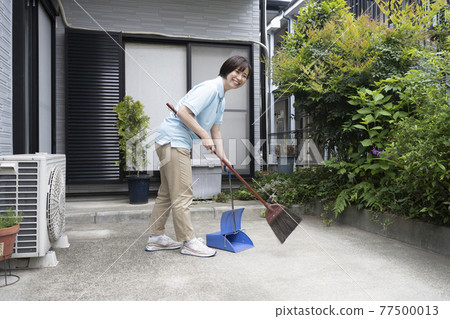 House cleaning woman sweeping the parking lot House cleaning woman sweeping the parking lot 77500013
