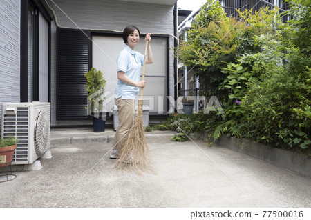 House cleaning woman sweeping the parking lot House cleaning woman sweeping the parking lot 77500016
