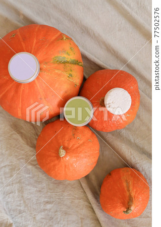 White soap in round aluminum metal tin on neutral background. Natural cosmetic product. Face and body skin care, cosmetic products with pumpkin White soap in round aluminum metal tin on neutral background. Natural cosmetic product. Face and body skin care, cosmetic products with pumpkin 77502576