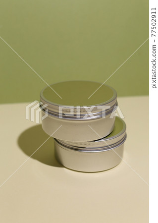 White cream in round aluminum metal tin on neutral background. Natural cosmetic product. Face and body skin care, cosmetic products. White cream in round aluminum metal tin on neutral background. Natural cosmetic product. Face and body skin care, cosmetic products. 77502911
