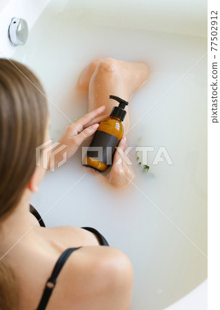 Woman's holding botles with spa cosmetics in bathroom. Beauty blogger, salon therapy, minimalism concept, copyspace Woman's holding botles with spa cosmetics in bathroom. Beauty blogger, salon therapy, minimalism concept, copyspace 77502912