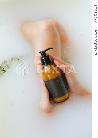 Woman's holding Amber botles with spa cosmetics in bathroom. Beauty blogger, salon therapy, minimalism concept, copyspace 77502914