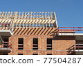 Roof frame made of raw wood on a red brick house 77504287