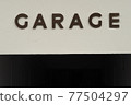 GARAGE written in capital letters on a white wall 77504297