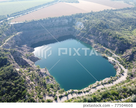 Black or Radon Lake in the Nikolaev region of Ukraine from a bird's eye view. Flooded granite quarry, aerial view, landscape. 77504608