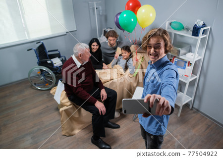 A family taking a selfie at the hospital room with a birthday girl lying in bed, everyone is making funny faces A family taking a selfie at the hospital room with a birthday girl lying in bed, everyone is making funny faces 77504922