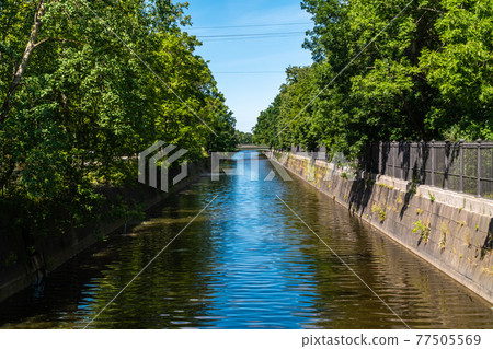 Russia. July 3, 2020. Picturesque summer view of the historic bypass canal, built for the passage of merchant ships and their unloading in the Admiralty warehouses of Kronstadt. 77505569