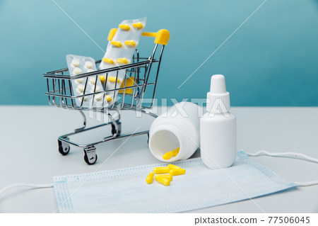 Shopping cart with compounded prescription medications shipped from a mail order pharmacy on a blue background Shopping cart with compounded prescription medications shipped from a mail order pharmacy on a blue background 77506045