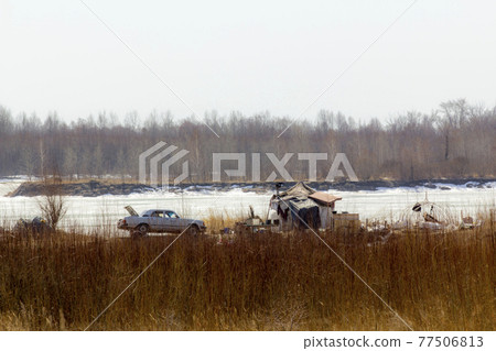 A ramshackle industrial waste refugee's winter home and his old rusty car. A ramshackle industrial waste refugee's winter home and his old rusty car. 77506813