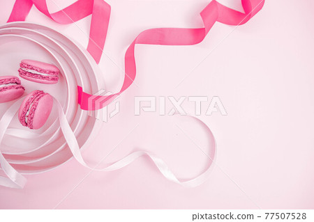 Valentine's Day. Pink background with macaroons. Ribbon heart, two hearts. Soft pastel love. Flat lay, top view. Valentines Day  77507528
