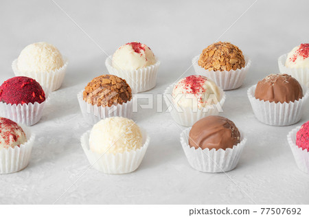 Homemade truffles on a white background. Candy or energy balls with chocolate, coconut, nuts, karkade and dried fruit. Healthy eat. Homemade truffles on a white background. Candy or energy balls with chocolate, coconut, nuts, karkade and dried fruit. Healthy eat. 77507692