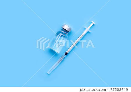 Bottle of vaccine and syringe on blue background with copy space. Covid-19 Coronavirus concept 77508749