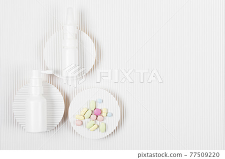 Medicine packs with the pile of pills on white corrugated paper background. Medicine packs with the pile of pills on white corrugated paper background. 77509220
