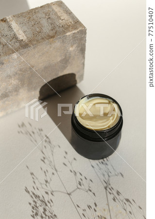 Cosmetic cream container with face or body cream on neutral background 77510407