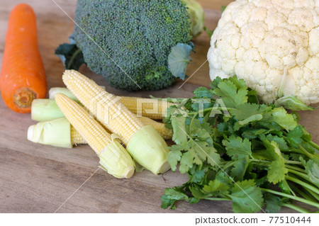 A collection of fresh and delicious vegetables on a wooden table 77510444