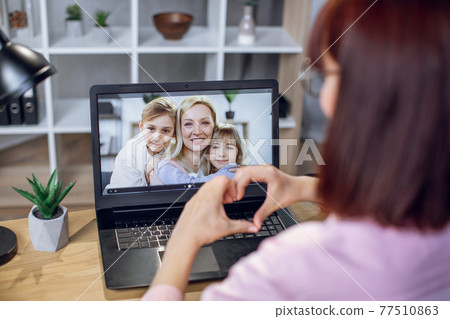 Young woman using laptop for video call with relatives Young woman using laptop for video call with relatives 77510863