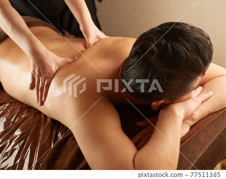 Asian man receiving back massage 77511385