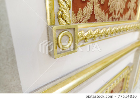 Close-up decorative gold stucco on the wall in luxurious expensive interior of a large baroque royal living room Close-up decorative gold stucco on the wall in luxurious expensive interior of a large baroque royal living room 77514810