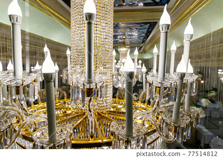Close up of large golden chandelier in the baroque interior Close up of large golden chandelier in the baroque interior 77514812