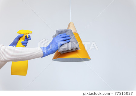 Hands in gloves removing dust, cleaning electric lamp, chandelier Hands in gloves removing dust, cleaning electric lamp, chandelier 77515057