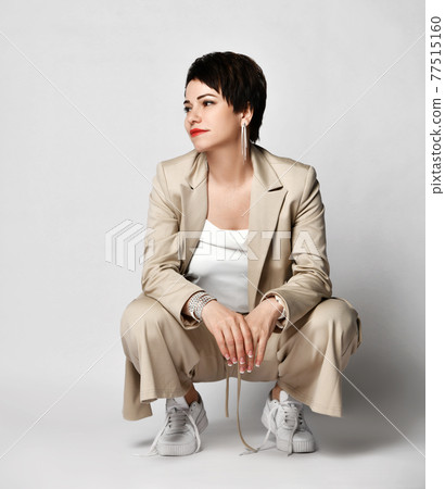 Adult woman in beige business casual pantsuit and Adult woman in beige business casual pantsuit and 77515160