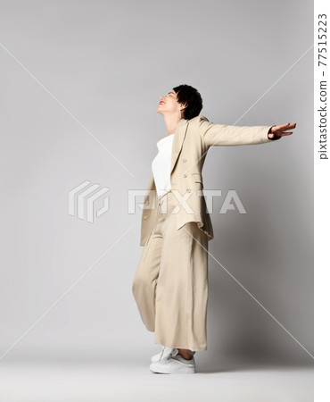 Happy adult woman in beige business casual Happy adult woman in beige business casual 77515223